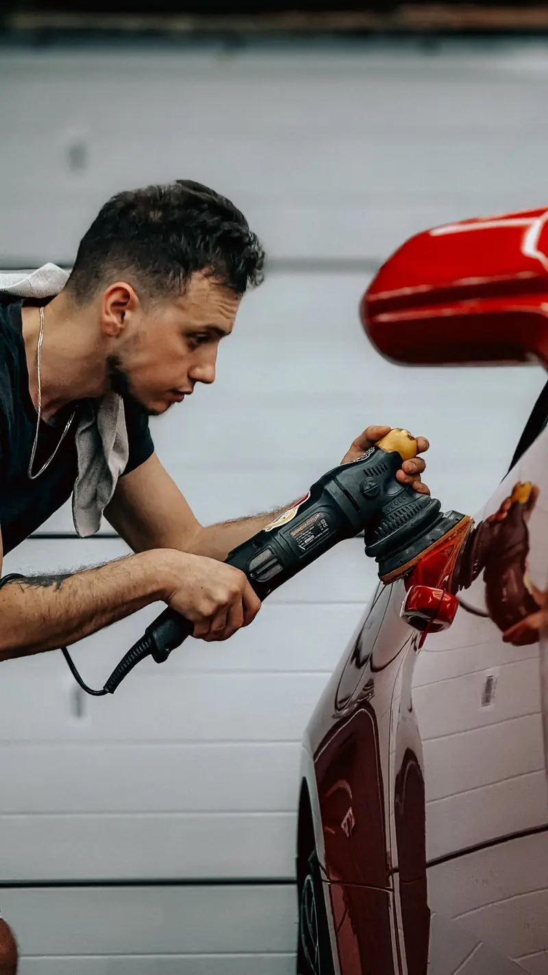 Machine polishing a car panel with careful attention